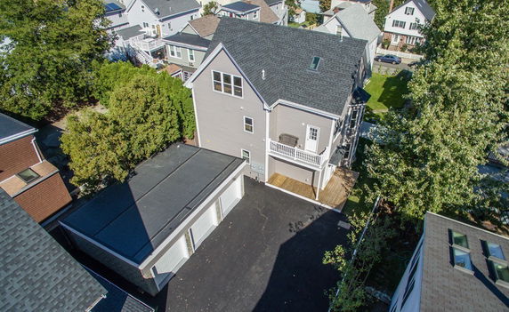 Aerial view of a multi-story house with a driveway.