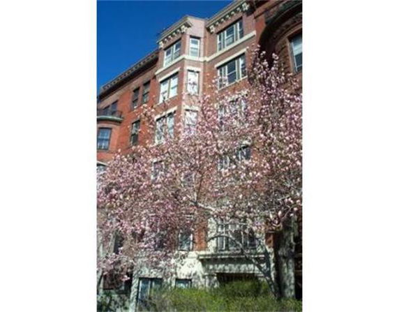 Front view of a multi-story brick building with large windows.