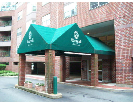 Front entrance of a brick building with a green canopy labeled Watermill Place.