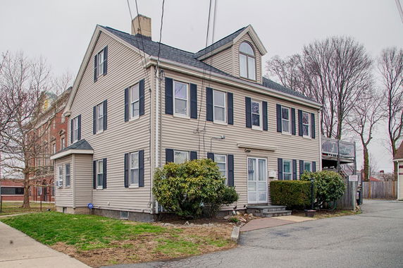 Front view of a two-story house with a gable roof and dormer window.
