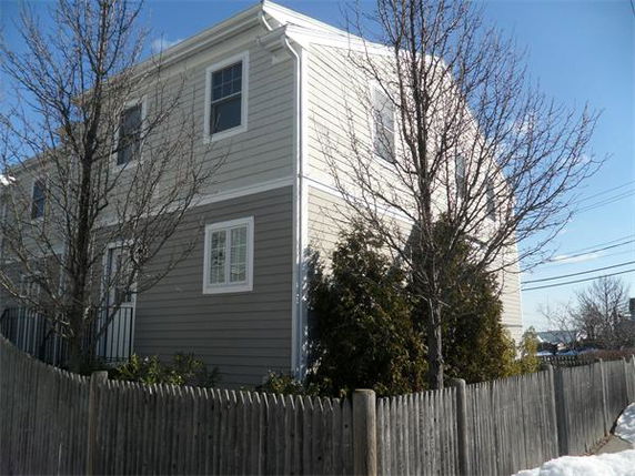 Front view of a two-story house with beige siding and white trim.