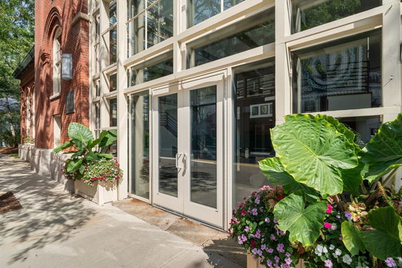 Front view of a building with large glass doors and a brick facade.