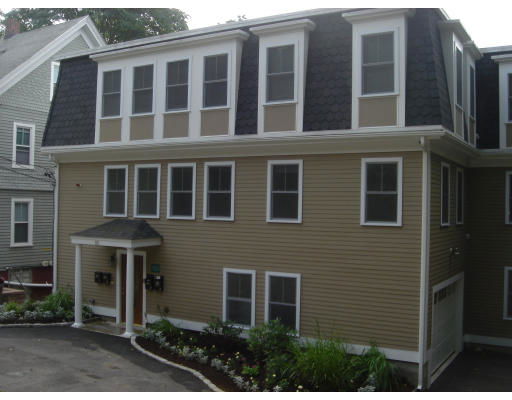 Front view of a three-story house with multiple windows and a small entrance porch.
