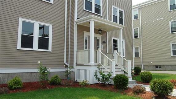 Front view of a multi-story building with a small porch entrance.