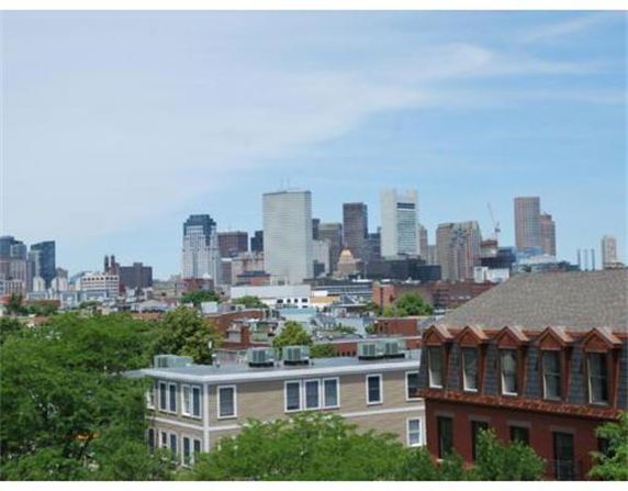 Wide angle view of a cityscape with various buildings and a clear sky.