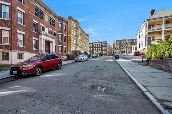Street view with brick apartment buildings on both sides.
