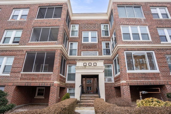 Front view of a brick multi-story apartment building.