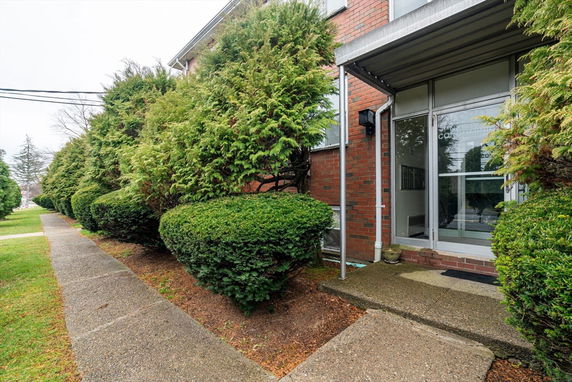 Front view of a building entrance with a glass door and metal awning.