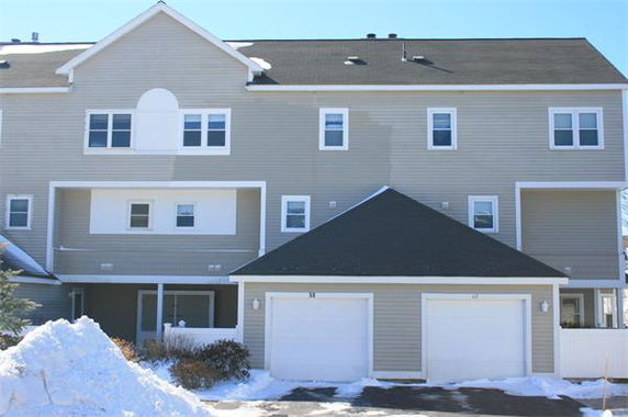 Front view of a multi-story house with connected garages.