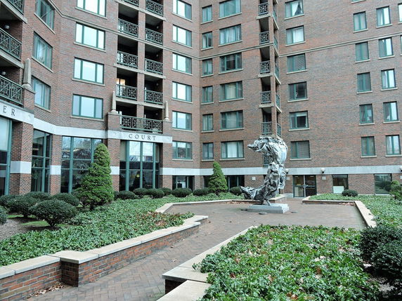 Front view of a multi-story brick building with balconies and large windows.