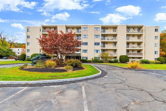 Front view of a multi-story apartment building with balconies.