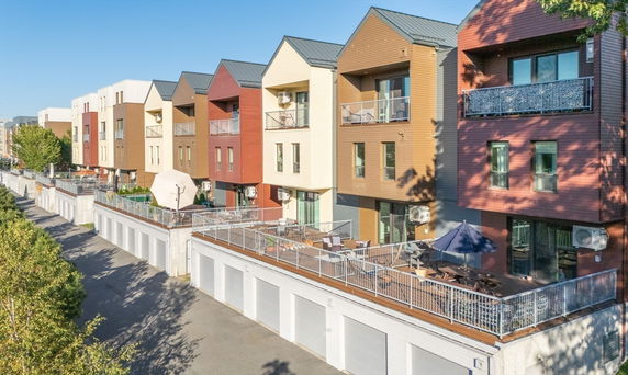 Front view of multi-story buildings with balconies and garage spaces below.