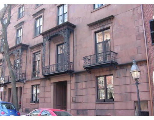 Front view of a multi-story residential building with iron balconies.