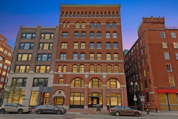 Front view of a multi-story brick building with arched windows.