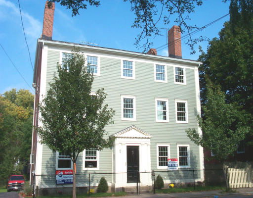 Front view of a multi-story house with chimneys.