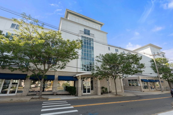 Front view of a multi-story commercial building with a central glass facade.