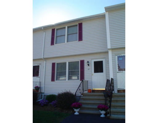 Front view of a two-story townhouse with white siding and purple shutters.