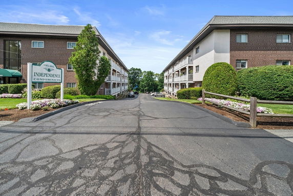 Front view of multi-story condominium buildings with brick facade.