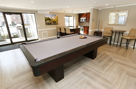 Room with a billiards table and seating area.
