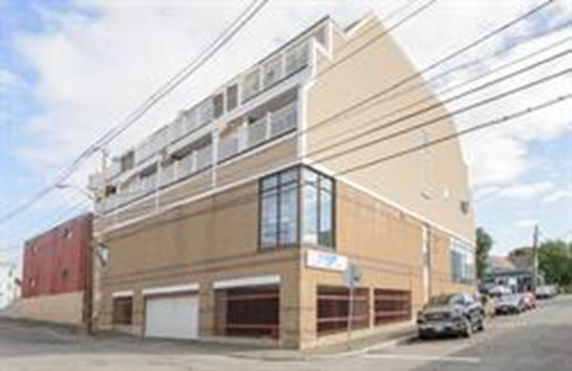 Front view of a multi-story building on a street corner.