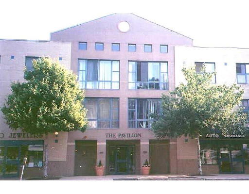 Front view of a multi-story commercial building with shops at the ground level.