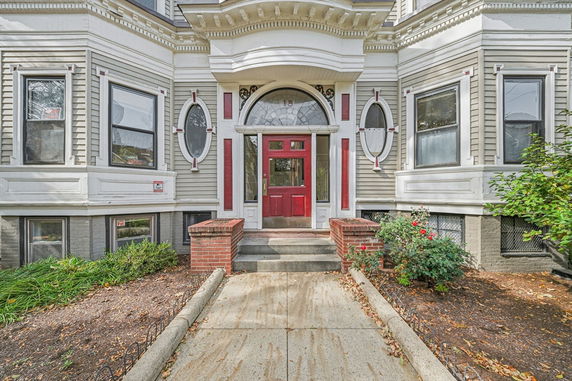 Front view of a house with decorative windows and a red door.