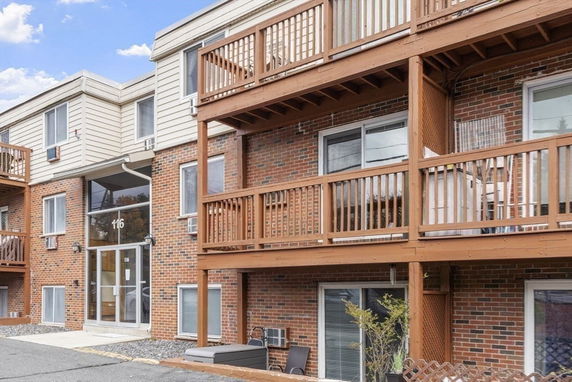 Front view of a multi-story brick building with balconies.