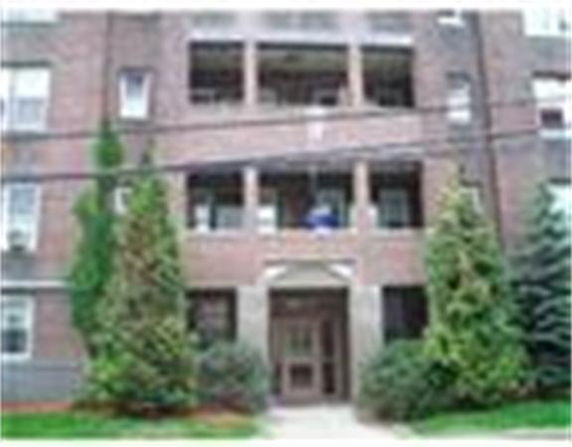 Front view of a multi-story brick building with balconies.