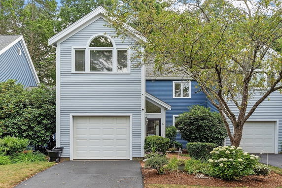 Front view of a two-story house with blue siding and a garage.