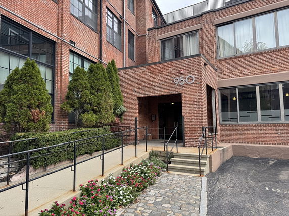 Front view of a building with brick exterior and multiple windows.