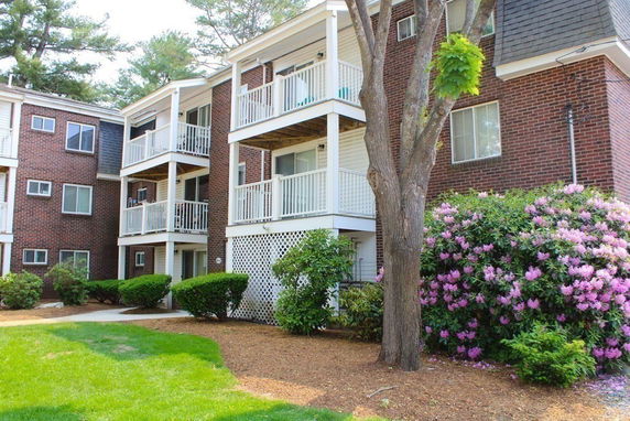 Front view of a multi-story brick apartment building with balconies.