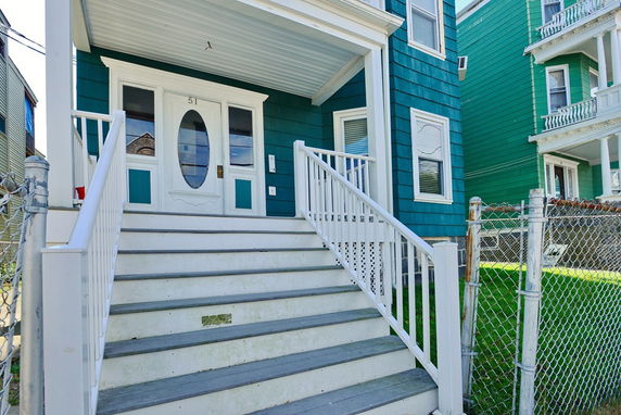 Front view of a house with teal siding and a covered porch.