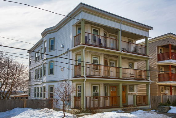 Front view of a three-story apartment building with balconies.