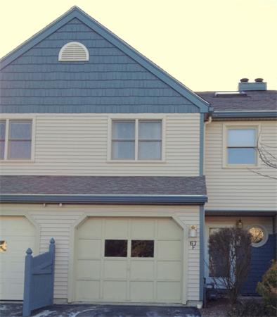 Front view of a two-story townhouse with a single garage.