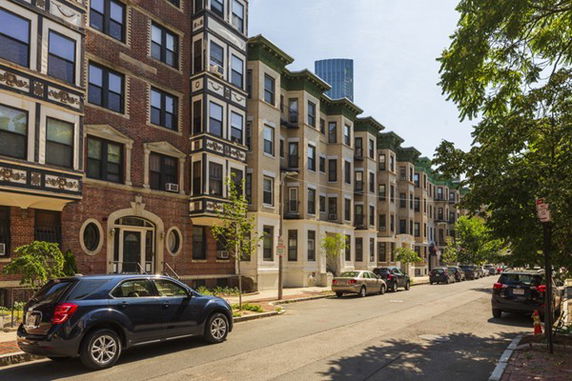 Front view of a row of multi-story residential buildings on a city street.