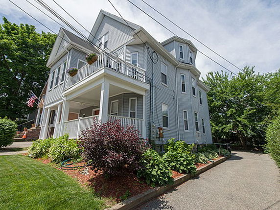 Front view of a two-story house with a porch and balcony.