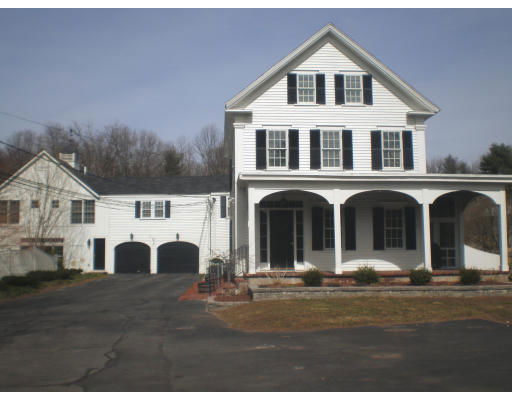 Front view of a two-story house with a covered porch and a three-car garage.