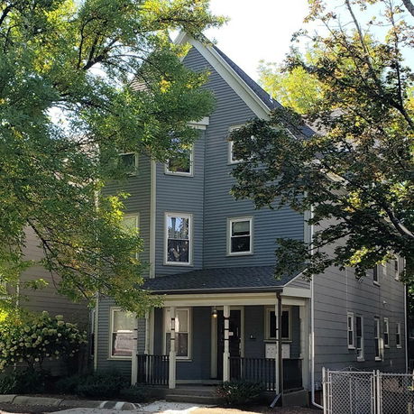 Front view of a two-story house with blue siding and a covered porch.