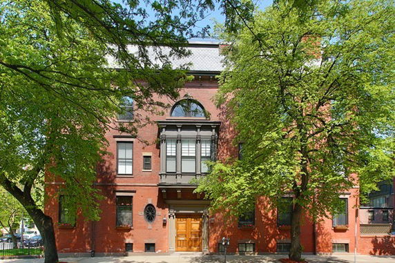 Front view of a multi-story brick building with large windows and decorative architectural features.
