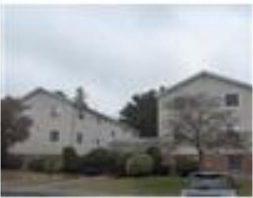 Front view of a multi-story residential building with an overcast sky.