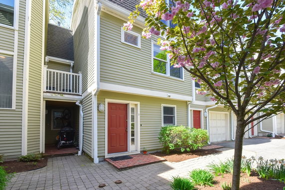Front view of a two-story house with red door and garage.