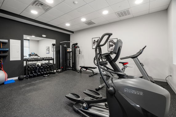 Interior view of a gym with exercise equipment and weights.