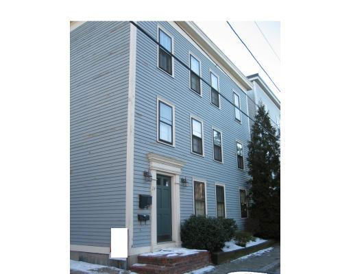 Front view of a multi-story house with blue siding and multiple windows.