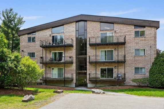 Front view of a multi-story apartment building with balconies.