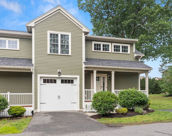 Front view of a two-story house with a single garage and front porch.