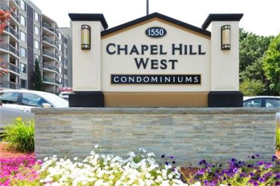 Front view of a condominium building with a sign that reads 'Chapel Hill West Condominiums'.