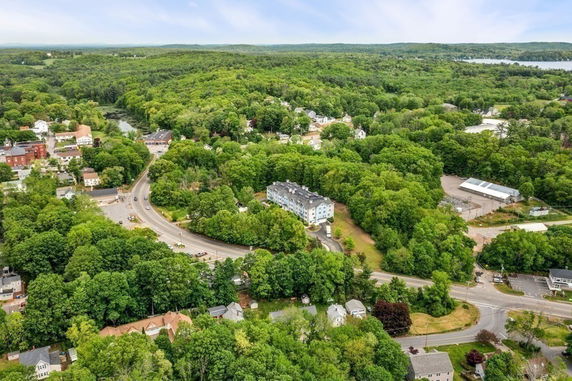 Wide aerial view of a residential area surrounded by dense forest.