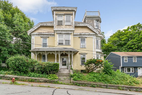 Front view of a multi-story house with a porch.