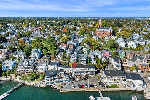 Panoramic view of a coastal town with numerous residential buildings and a waterfront.