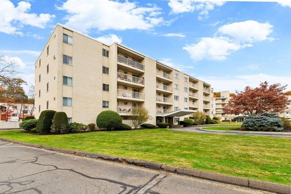 Front view of a multi-story apartment building with balconies.